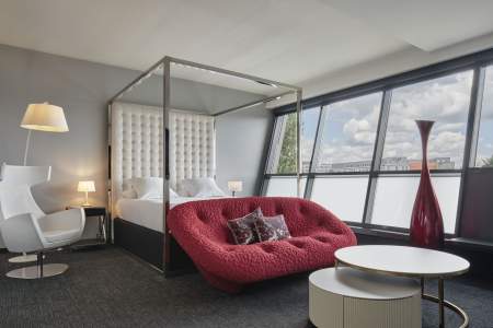 Suite avec salon et canapé rouge de l'Hôtel Athena Spa