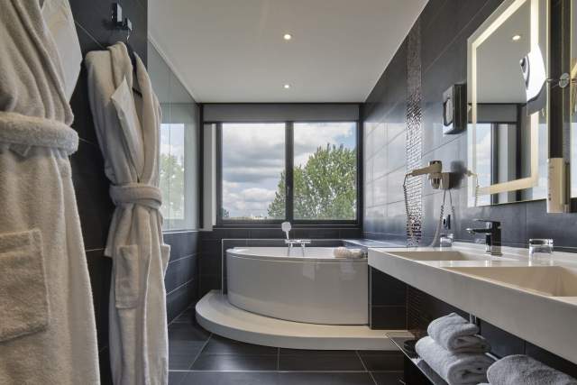 Bathroom with spa bath at Hôtel Athena Spa in Strasbourg