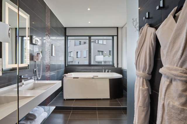 Bathtub with vanity in a bathroom at Hôtel Athena Spa in Strasbourg