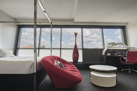 Chambre avec fauteuil rouge et vue sur Strasbourg de l'Hôtel Athena Spa